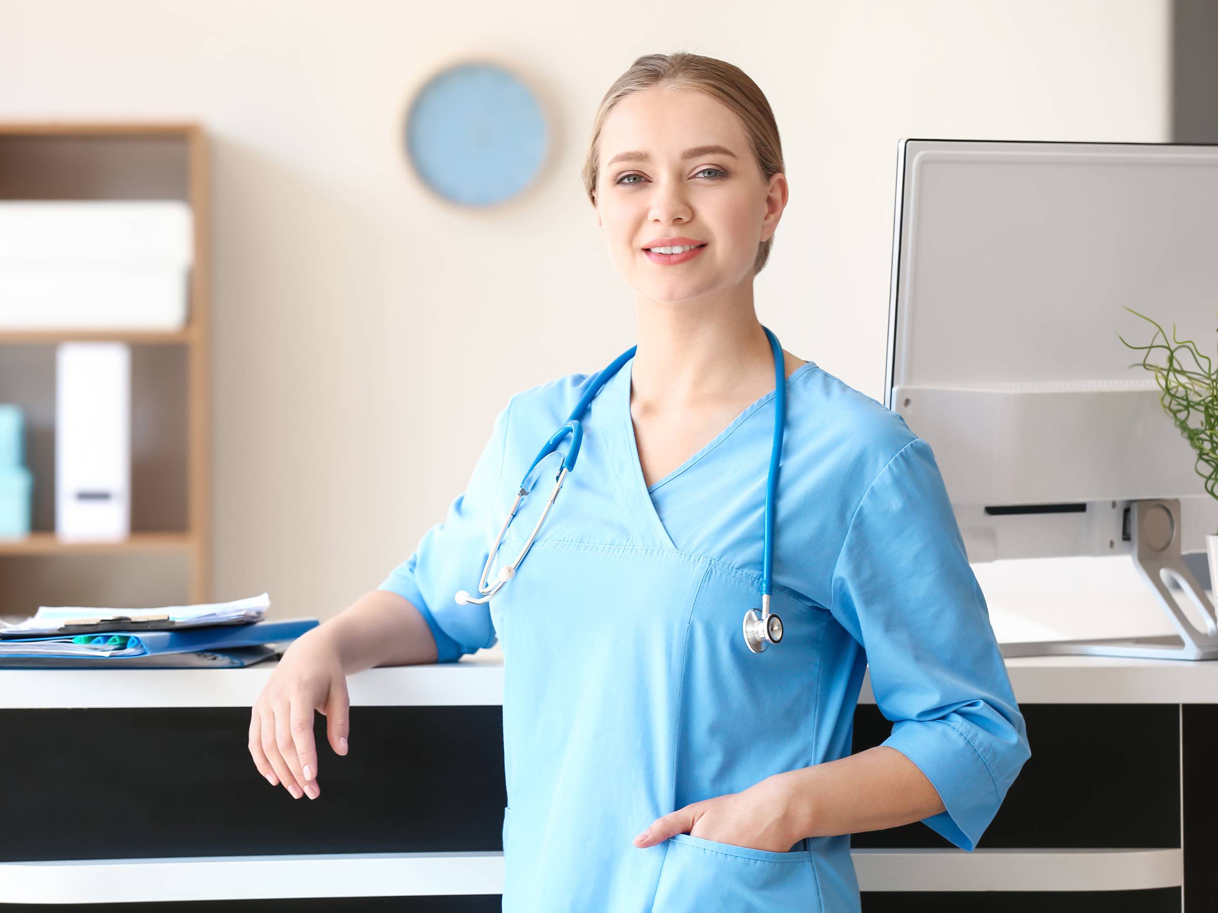Medical Office Manager standing confidently in medical office reception area